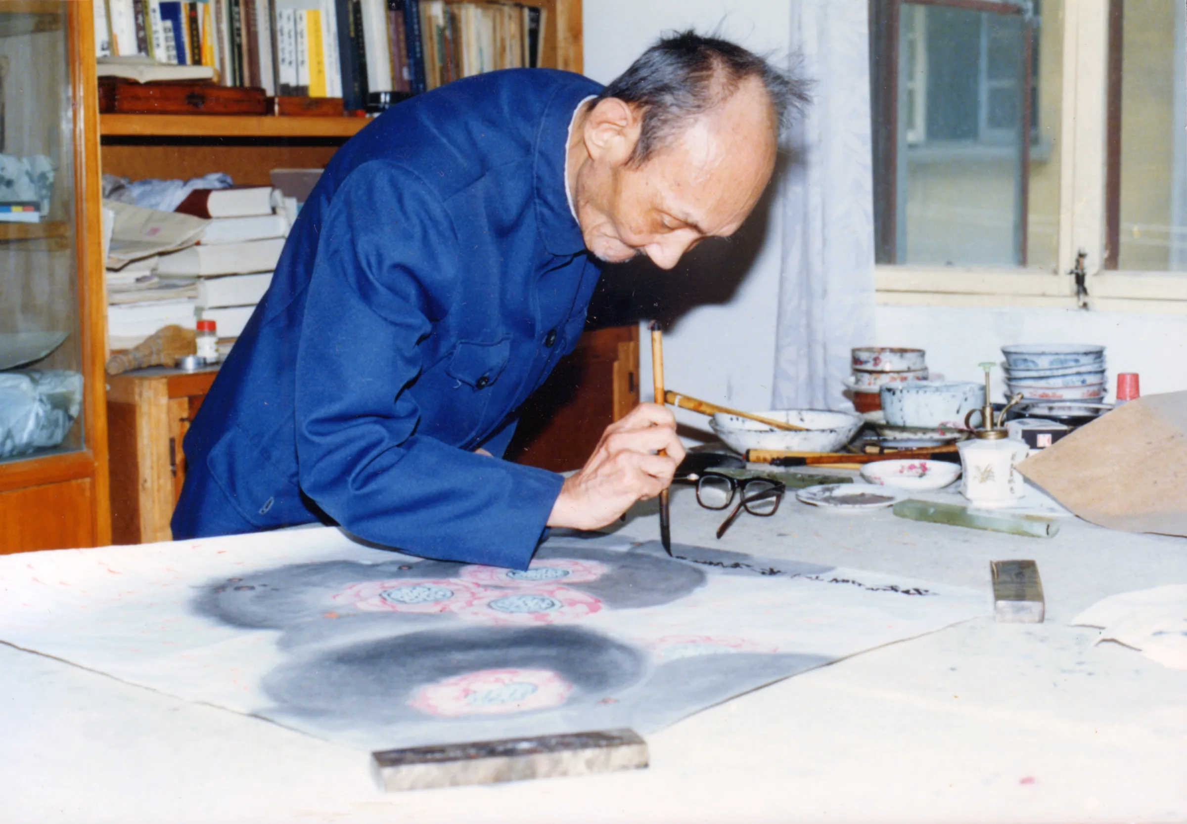 Yang Jianhou painting at his desk